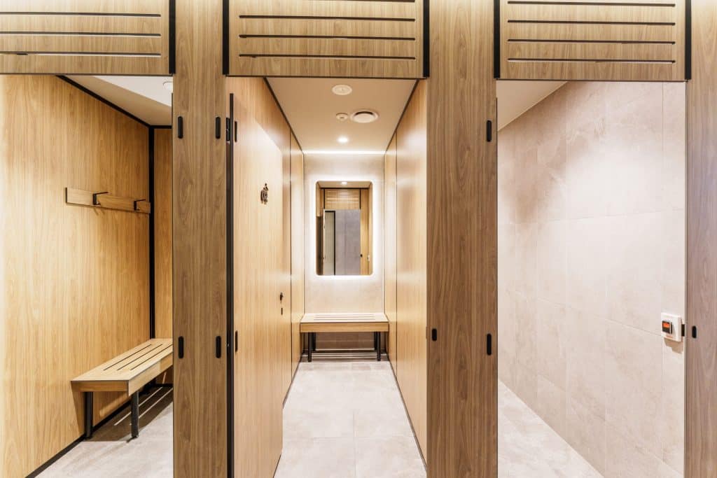 Full height privacy core compact laminate cubicles with slotted airflow panels in a 24 hour gym