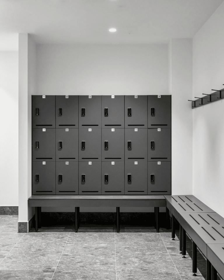 Bench mounted compact laminate lockers in charcoal at an elite sporting facility.